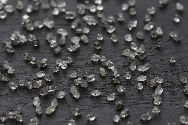 Scattered diamonds on a black background. Raw diamonds and minin