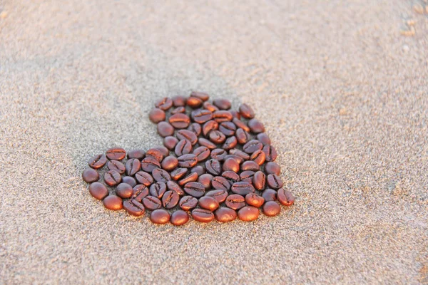 Hart van koffie. Granen van koffie zijn aangelegd op zand in de fo — Stockfoto