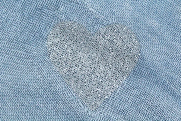 Серебряное сердце на синем фоне хлопковой ткани. Романтические па — стоковое фото