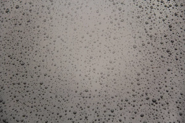 La pluie tombe sur la voiture. Gris fond de gouttes de pluie. Pour votre De — Photo