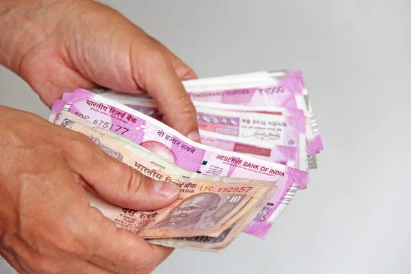 A mão de um homem segura o dinheiro indiano e conta-os. Papel Ba indiano — Fotografia de Stock