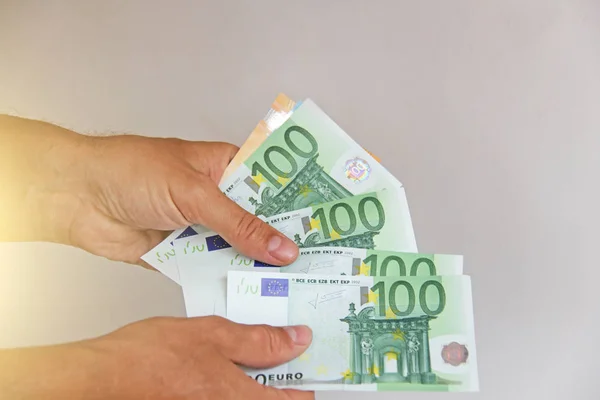 The man's hand holds the 100 euro, considers them and pays. Pape — Stock Photo, Image