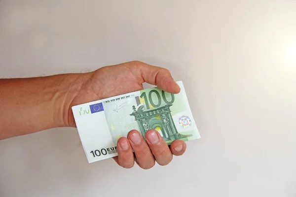 Ręka mężczyzny trzyma 100 euro, uważa je i płaci. Pape — Zdjęcie stockowe