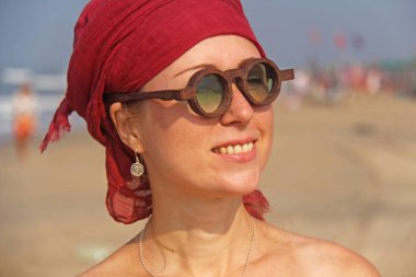 Başında kırmızı bir kol bandı olan güzel kız ucubesi, sırtında