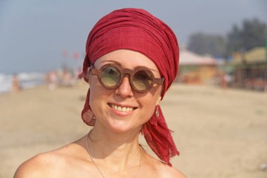 Başında kırmızı bir kol bandı olan güzel kız ucubesi, sırtında