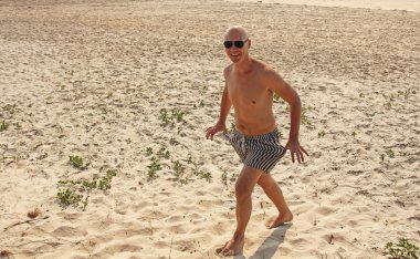 Çıplak göğüslü kel adam, çizgili mayolar veya s