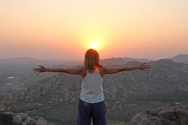 The girl at sunset. The girl stands with her back on the top of