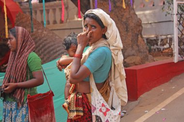 Hindistan, Goa, 28 Ocak 2018. Kollarında bir bebek ile zavallı kadın