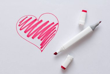 Parlak kırmızı bir keçeli kalemle ya da beyaz bir arka planda kırmızı bir kalple çizilmiş. Aşk, romantizm, sevgililer günü. Basit çizim, kalp. Çift taraflı keçeli kalem..