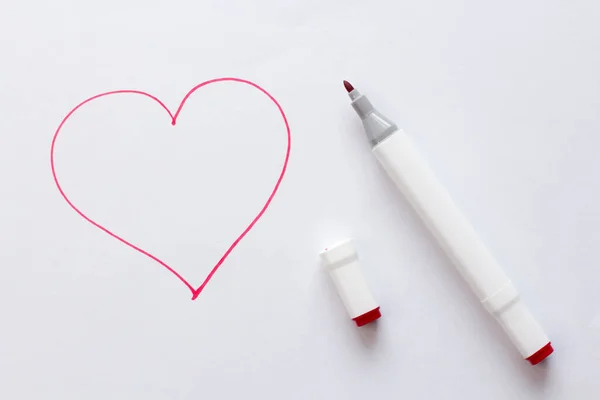 Drawn by a bright red felt-tip pen or marker a red heart on white paper and a white background. Love, romance, valentines day. Simple drawing, heart.