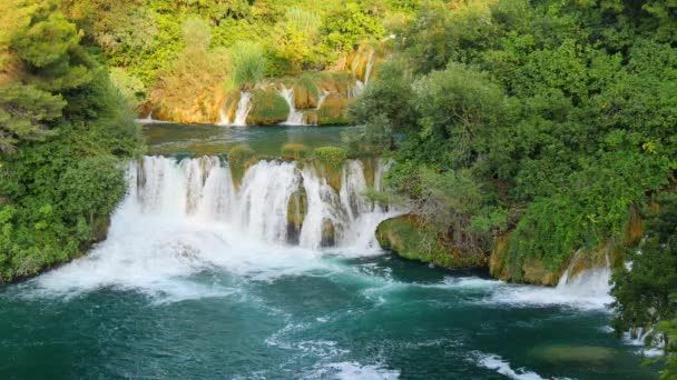 Vodopády Krka, Národní park, Chorvatsko. Krásné potoky pomalu teče v Národním parku Krka mezi stromy a trávou, kaskáda vodopádů. Zpomalené video vody, řeky, potoka, vodopády.