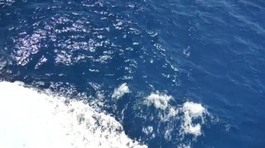Köpüklü yüzeyi olan deniz suyu. Tekne yolculuğu, deniz köpüğü, mavi köpük, deniz arka planı dalgaları. Dalgalı derin turkuaz ve beyaz köpüklü mavi Akdeniz. Tekne uyanışından su püskürtme. Yavaş çekim videosu.