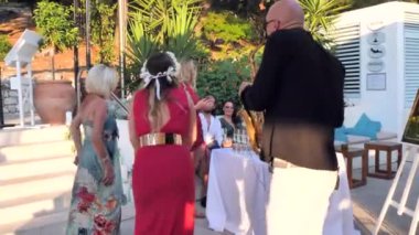 Hırvatistan, Hvar Adası, 16 Ağustos 2019. Saxophonist bir adam deniz kıyısındaki bir düğünde altın alto saksafon çalar. Gece elbiseli güzel kızlar şampanya içer, düğünde dans eder..
