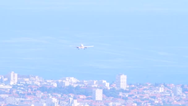 一架开着前灯的白色飞机降落在蓝天 大海和有梯形屋顶的家 克罗地亚斯普利特机场1 飞机概况 — 图库视频影像