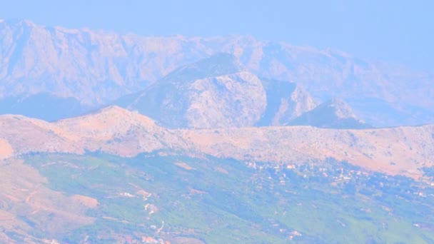 スプリット市の近くのクロアチアの山々の眺め 青い山とタイル張りのテラコッタの屋根の家 夏には 熱い空気が表示され 空気中の蜃気楼 — ストック動画
