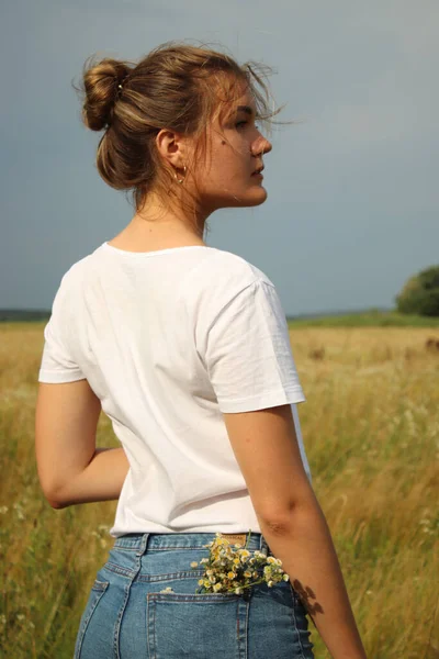 Портрет блондинки очаровательной красивой женщины в белой футболке и джинсовых шортах на пшеничном поле — стоковое фото