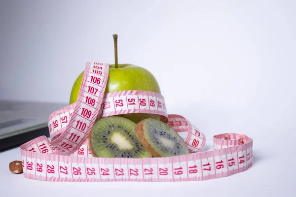 Cinta métrica roja, manzana verde y kiwi cerca de básculas de baño. Dieta y Vida sana, pérdida de peso, concepto deportivo. Copiar espacio. Aislado. Fondo blanco — Foto de Stock