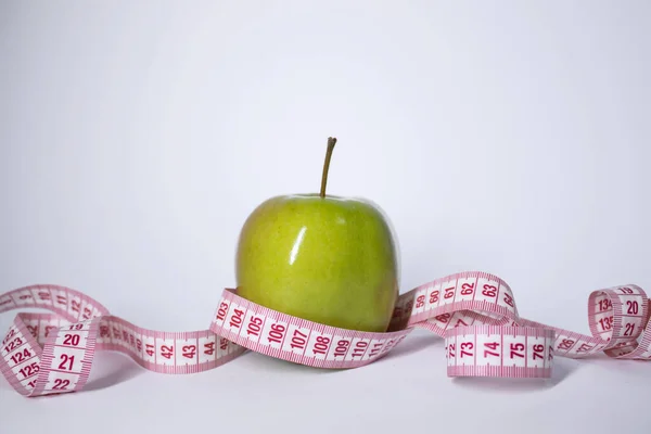 Cinta métrica roja sobre manzana verde. La dieta y la vida saludable, concepto de pérdida de peso. Vista superior. Copiar espacio. Aislado. Fondo blanco — Foto de Stock