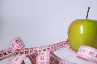 Yeşil elma yerine kırmızı şerit. Diyet ve sağlıklı yaşam, kilo verme konsepti. Üst Manzara. Uzayı kopyala İzole edilmiş. Beyaz arkaplan