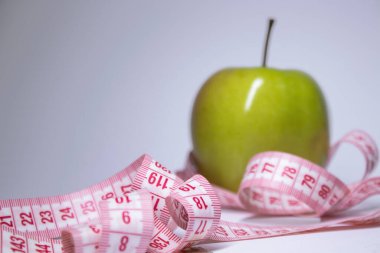 Yeşil elma yerine kırmızı şerit. Diyet ve sağlıklı yaşam, kilo verme konsepti. Üst Manzara. Uzayı kopyala İzole edilmiş. Beyaz arkaplan