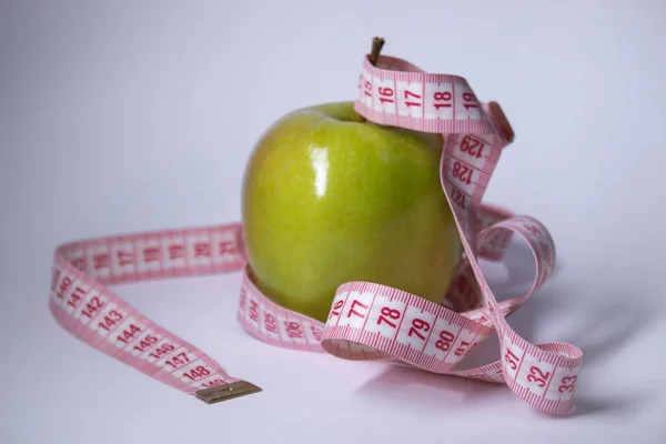 Cinta métrica roja sobre manzana verde. La dieta y la vida saludable, concepto de pérdida de peso. Vista superior. Copiar espacio. Aislado. Fondo blanco — Foto de Stock