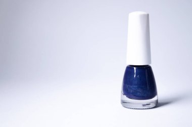 Beyaz arka planda mavi ojeli bir şişe. Tırnak törpüsü. Tırnak manikürü konsepti. İzole edilmiş, kopyalama alanı