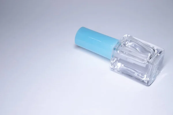 Uma garrafa com esmalte azul sobre fundo branco. laca de unhas. Conceito de manicure nas unhas. Isolado, espaço de cópia — Fotografia de Stock