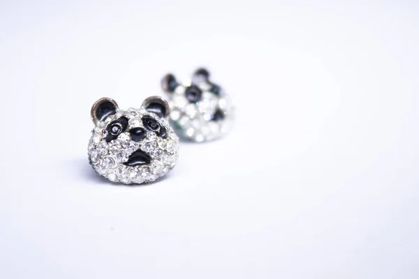 Stříbrné náušnice ve tvaru pandy. šperky a příslušenství koncepce. Izolované, kopírujte prostor. Makro snímek — Stock fotografie