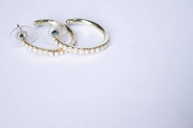 Beyaz taşlı yuvarlak altın küpeler. Mücevher ve aksesuar konsepti. İzole edilmiş, kopyalama alanı. Makro Vuruş