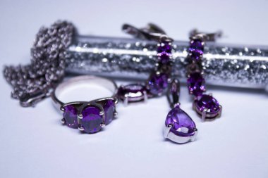 Mor taşlı, yüzüklü, kolyeli ve küpeli pahalı gümüş kadın mücevherleri. İzole edilmiş, kopyalama alanı