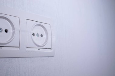 Açık gri bir duvarda elektrik prizleri var. çoklu fonksiyon çıkışı
