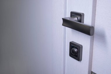 İçerideki kapı kolu. Tokmak yakın çekim elementleri. İç mekanda modern tarzda aydınlık ahşap kapılar