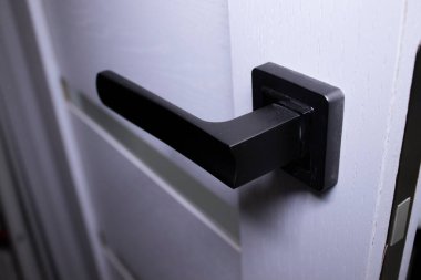 İçerideki kapı kolu. Tokmak yakın çekim elementleri. İç mekanda modern tarzda aydınlık ahşap kapılar