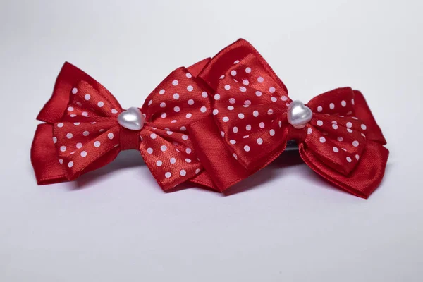 Two red polka dot bow hairpins with a heart in the middle. accessories concept. Isolated, copy space. Macro Shot — Stock Photo, Image