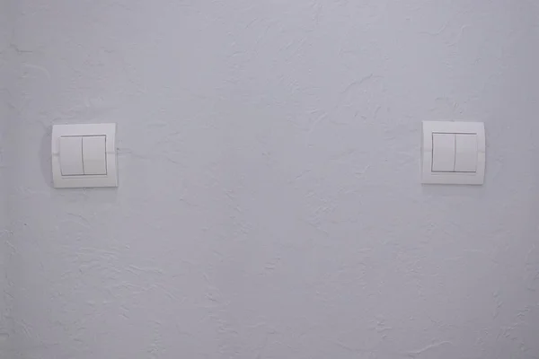 Interruttore meccanico a luce bianca in plastica, installato su una parete grigio chiaro — Foto Stock