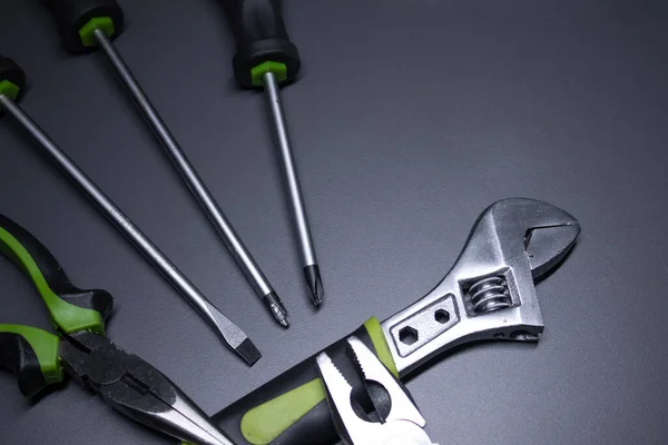 A set of building tools and instruments for repair in black and green colour. Must-have for men. Equipment for building. Repair tool kit. construction concept. gray background