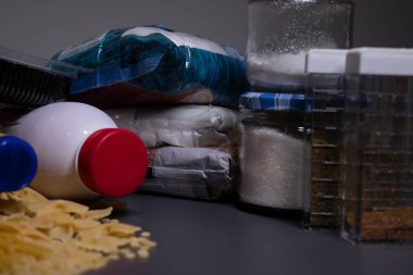 Gri bir masanın üzerinde yiyecek yığını. Yiyecek bağışı konsepti. Coronavirus salgınının içeriği. Boşluğu kopyala