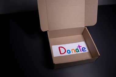 El yazısıyla yazılmış çok renkli mektupları bir kutuya bağışlayın. Bağış konsepti. Coronavirus salgınının içeriği