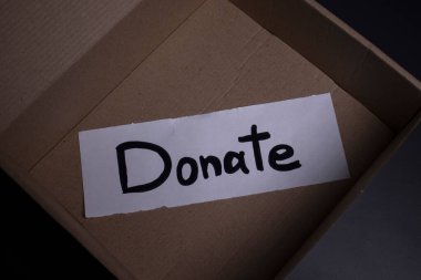 Kutuda siyah harflerle el yazısıyla yazılmış bir bağış yazısı. Bağış konsepti. Coronavirus salgınının içeriği. Boşluğu kopyala