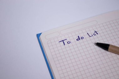 Üzerinde kalem ve yapılacaklar listesi olan mavi bir defter. El yazısı. Kırtasiye konsepti. kopyalama alanı. izole