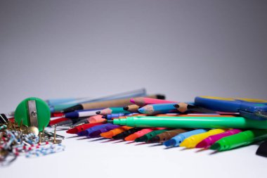 Bir yığın farklı kırtasiye. çok renkli kalemler, ataçlar, iğneler, kalemler, kalemler