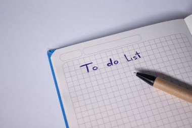 Üzerinde kalem ve yapılacaklar listesi olan mavi bir defter. El yazısı. Kırtasiye konsepti. kopyalama alanı. izole