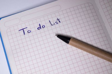 Üzerinde kalem ve yapılacaklar listesi olan mavi bir defter. El yazısı. Kırtasiye konsepti. kopyalama alanı. izole