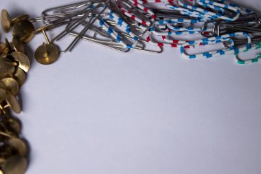 Altın raptiyeler ve renkli ataçlar. Kırtasiye konsepti. kopyalama alanı. izole
