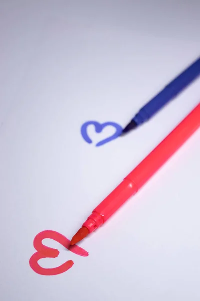 multicoloured felt-tip pen with a painted heart next to it. stationery concept. copy space. isolated