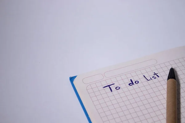 Blauw notitieboekje met een pen erop en een bord om er een lijst van te maken - handgeschreven. briefpapier concept. kopieer ruimte. geïsoleerd — Stockfoto