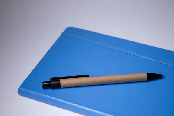 Blauw notitieboekje met een pen erop. briefpapier concept. kopieer ruimte. geïsoleerd — Stockfoto