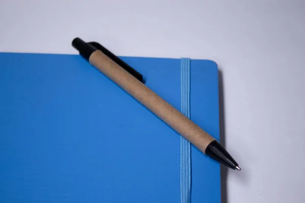 Blauw notitieboekje met een pen erop. briefpapier concept. kopieer ruimte. geïsoleerd — Stockfoto