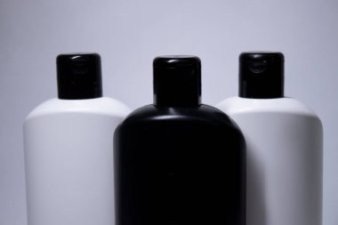 Etiketsiz üç beyaz ve siyah şampuan şişesi kompozisyonu. vücut bakımı ve güzellik konsepti. Boşluğu kopyala. 