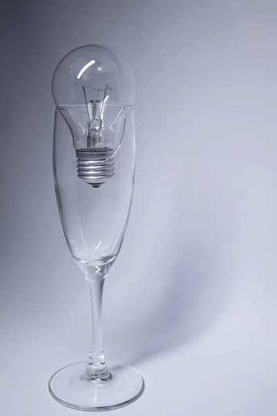 Light bulb in a broken glass on a white background. Copy space. Isolated — Stock Photo, Image